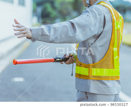 一個穿著工作服的男人在指揮交通 96530327