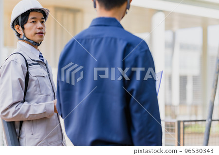 A man in his thirties wearing work clothes 96530343