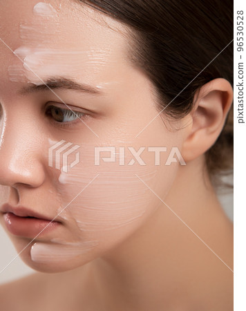 Beautiful woman applying moisturizer cream on her 96530528