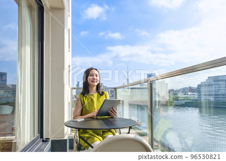 Young woman operating a tablet on the balcony Young woman operating a tablet on the balcony 96530821