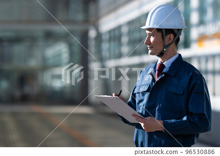 A man in his thirties wearing work clothes 96530886