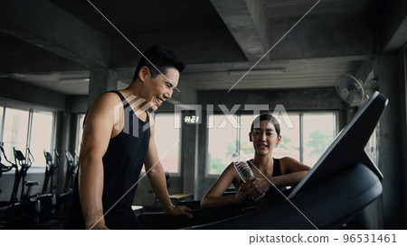 Fitness concept of 4k Resolution. Asian man and woman talking while exercising in the gym. Fitness concept of 4k Resolution. Asian man and woman talking while exercising in the gym. 96531461