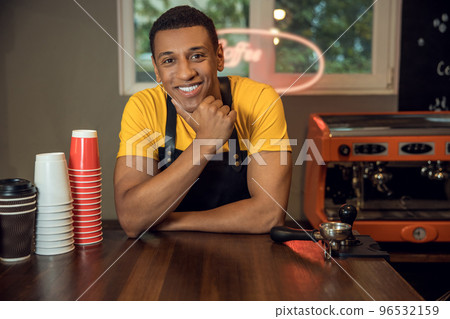 Smiling happy barista posing for the camera in the workplace Smiling happy barista posing for the camera in the workplace 96532159