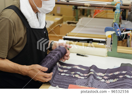 Craftsmen checking kimono rolls in the workshop 96532556