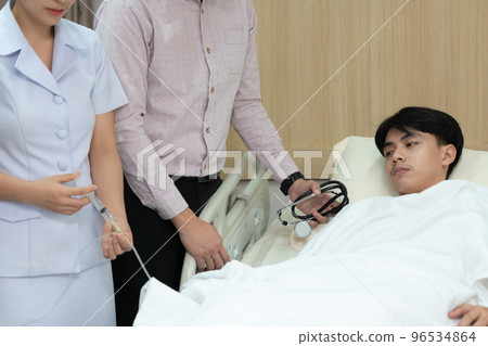 Doctor and nurse inject medicine, dosage into IV tube in sterile recovery room Doctor and nurse inject medicine, dosage into IV tube in sterile recovery room 96534864