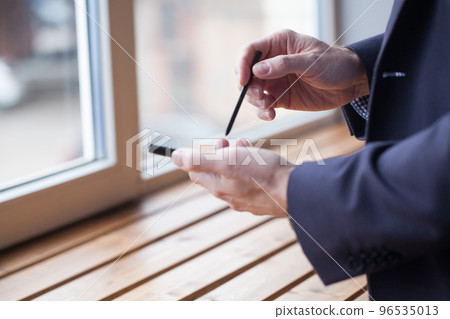 Mobile phone and stylus in male hands 96535013