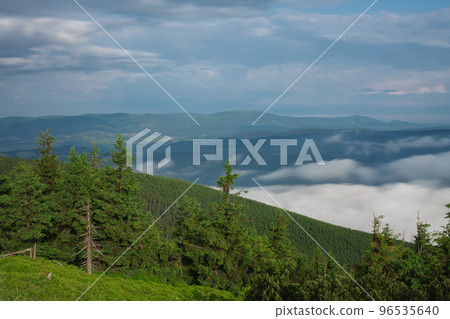 View from Serak in Jeseniky mountains on a summer foggy morning and sea of clouds around mountain peak View from Serak in Jeseniky mountains on a summer foggy morning and sea of clouds around mountain peak 96535640