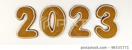 Gingerbread cookies in the form of numbers 2023 in the center on a white background. New year concept, top view, tiles. Gingerbread cookies in the form of numbers 2023 in the center on a white background. New year concept, top view, tiles. 96535771