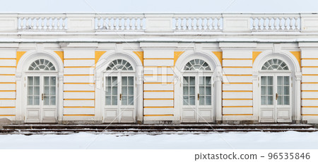 Old white wooden doors in yellow outdoor wall, background photo 96535846