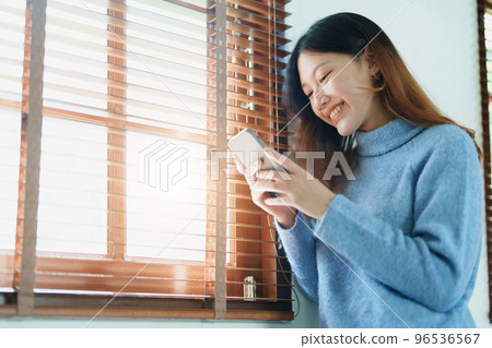 Portrait of a beautiful Asian teenage girl using a smartphone mobile. 96536567