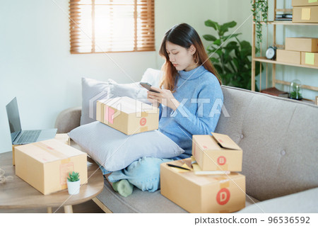 Starting small business entrepreneur of independent Asian woman smiling using computer laptop with cheerful success of online marketing package box items and SME delivery concept. Starting small business entrepreneur of independent Asian woman smiling using computer laptop with cheerful success of online marketing package box items and SME delivery concept. 96536592