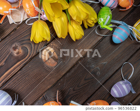 Bouquet of spring yellow tulips and colorful easter eggs on brown wooden background 96536822