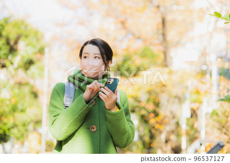 A woman in a coat and a mask Smartphone A woman in a coat and a mask Smartphone 96537127