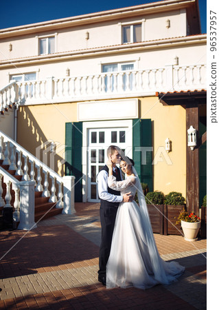 Newlyweds tenderly hug, kiss and enjoy each other. Walk of lovers. Amazing smiling wedding couple. Love. Newlyweds tenderly hug, kiss and enjoy each other. Walk of lovers. Amazing smiling wedding couple. Love. 96537957