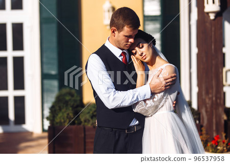 Newlyweds tenderly hug, kiss and enjoy each other. Walk of lovers. Amazing smiling wedding couple. Love. Newlyweds tenderly hug, kiss and enjoy each other. Walk of lovers. Amazing smiling wedding couple. Love. 96537958