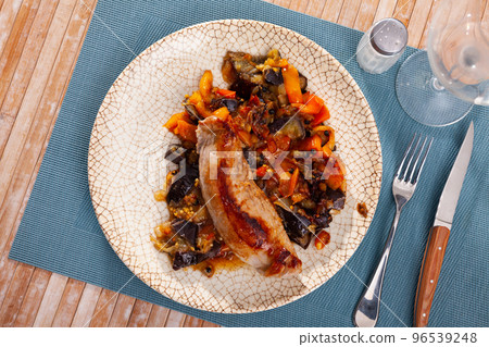 Roasted pork loin served with garnish of baked vegetables 96539248