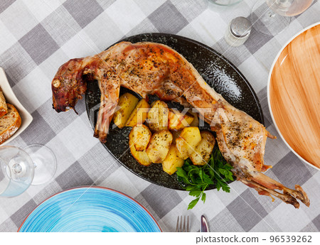 Whole roasted rabbit with baked potatoes and fresh herbs 96539262
