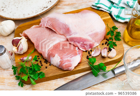Raw slice of Iberian pork secret on wooden cutting board with seasonings Raw slice of Iberian pork secret on wooden cutting board with seasonings 96539386