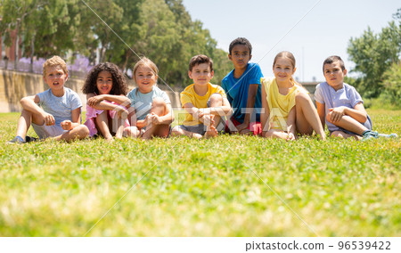 Group of happy kids on green grass in park Group of happy kids on green grass in park 96539422