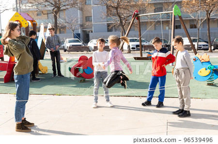 Children skipping on elastic jump rope 96539496