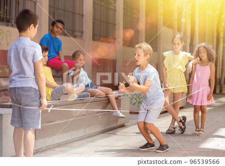 Little boy jumping on rubber band with friends in historical center 96539566