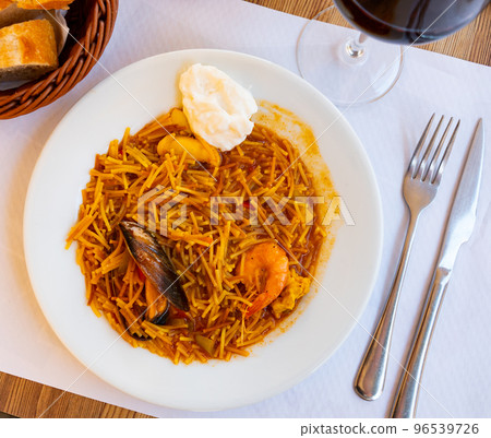 Traditional spanish seafood dish fideua with aioli sauce in restaurant Traditional spanish seafood dish fideua with aioli sauce in restaurant 96539726