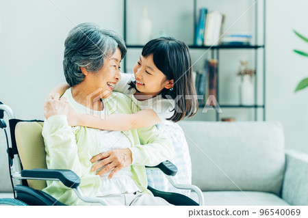 輪椅祖母和小學孫女在客廳 96540069