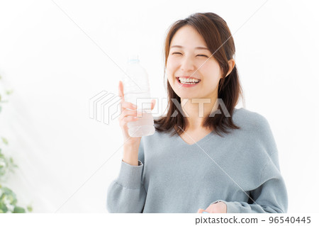A woman drinking water 96540445