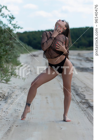 Sensual woman standing on seashore 96540476