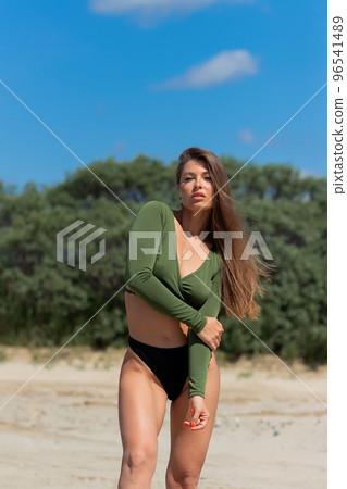 Attractive woman standing on seashore 96541489
