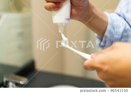 Apply toothpaste to the toothbrush 96541530