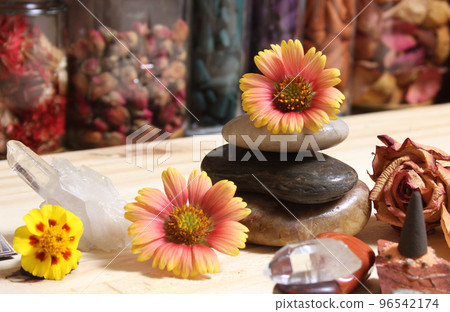 Quartz Crystal Balanced on Bloodstone With Flowers in Background Shallow DOF Quartz Crystal Balanced on Bloodstone With Flowers in Background Shallow DOF 96542174