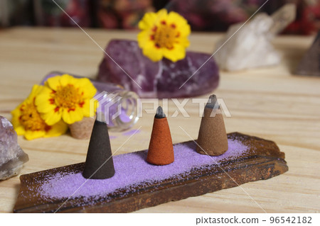 Incense Cones on Stone Slab With Crystals and Flowers Incense Cones on Stone Slab With Crystals and Flowers 96542182