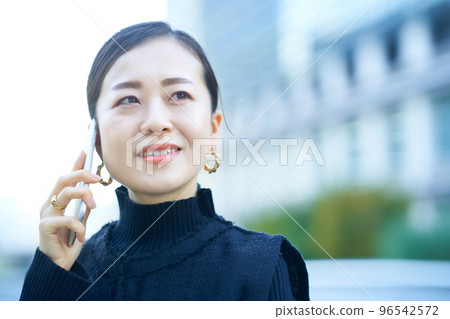 A woman talking on a smartphone 96542572