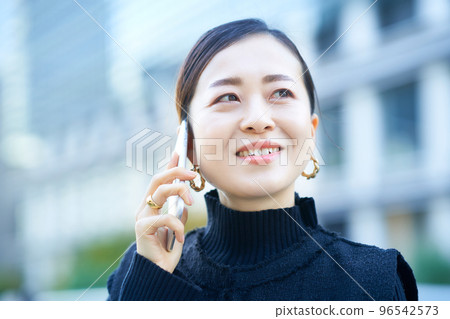 A woman talking on a smartphone 96542573