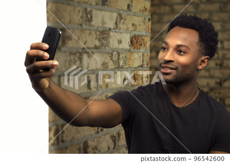 man taking selfie brick wall cellphone student holding smartphone social networking man taking selfie brick wall cellphone student holding smartphone social networking 96542600