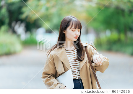 Young woman walking with a computer Young woman walking with a computer 96542936