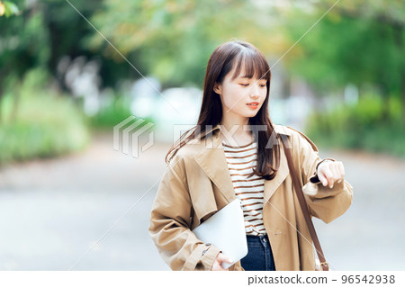 Young woman walking with a computer 96542938