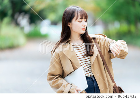 Young woman walking with a computer Young woman walking with a computer 96543432