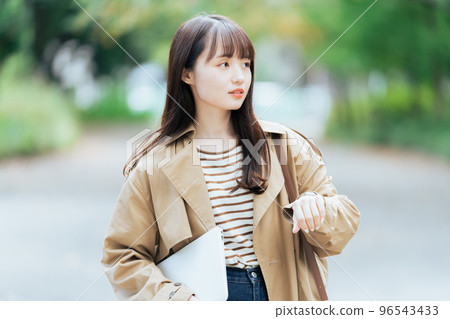Young woman walking with a computer 96543433