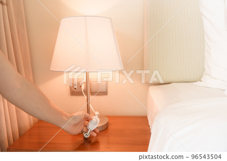 Woman hand turning on or turning off switch the minimal lamp in modern bedroom. Apartment living concept 96543504