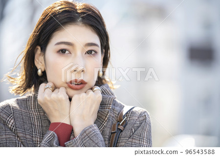 Young woman holding the collar of her coat Young woman holding the collar of her coat 96543588