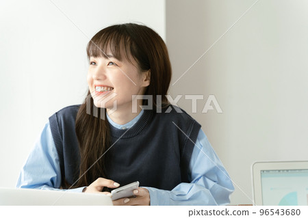 Young woman working at a computer Young woman working at a computer 96543680