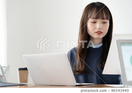 Young woman working at a computer 96543940