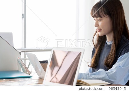 Young woman working at a computer Young woman working at a computer 96543945
