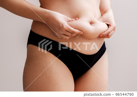 Fat woman hand holding excessive belly fat Fat woman hand holding excessive belly fat 96544790