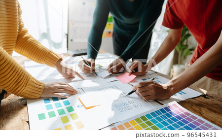 UX developer and ui designer brainstorming about mobile app interface wireframe design with customer breif and color code at office.. UX developer and ui designer brainstorming about mobile app interface wireframe design with customer breif and color code at office.. 96545431