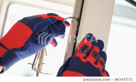 Male worker in protective gloves adjusting lock of pvc windows with special key 96545555