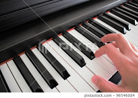 Female fingers practicing the piano 96546884