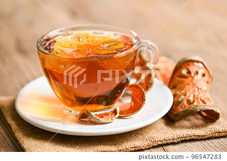 Bael tea on glass with dried bael slices on wooden background, Bael juice - Dry bael fruit tea for health - Aegle marmelos Bael tea on glass with dried bael slices on wooden background, Bael juice - Dry bael fruit tea for health - Aegle marmelos 96547283